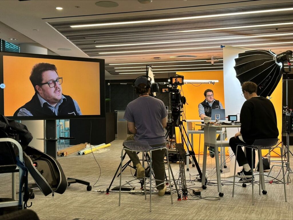 Aaron Patrick being filmed in a video studio