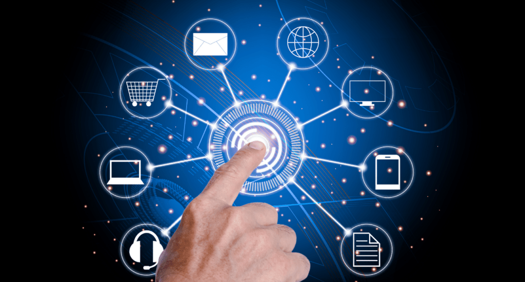 A hand points to a glowing digital interface, illustrating MTD IT transformation. With interconnected icons—envelope, globe, monitor, smartphone, document—all set against a dark blue background with light trails, this prepares accountants for modern practices with laptops and shopping carts.