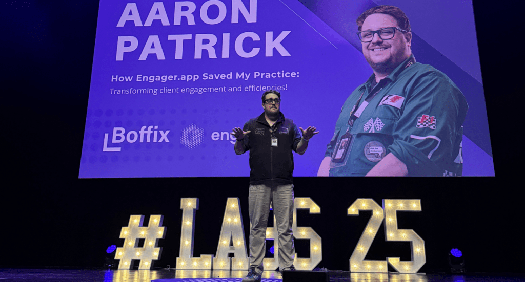 Aaron Patrick, The QuickBooks Chap, stands on stage in front of a large screen showcasing Aaron Patrick alongside details about his groundbreaking presentation on Engager.app, catalyzing Firm Transformation. The stage is adorned with illuminated letters spelling #LAS25.