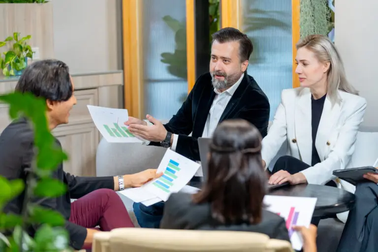 Four colleagues discussing documents in an office meeting