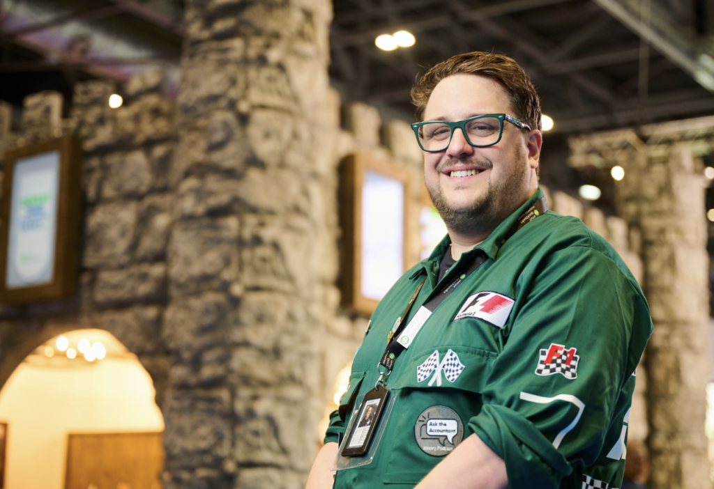 Aaron Patrick smiling in a green motorsport-style jacket