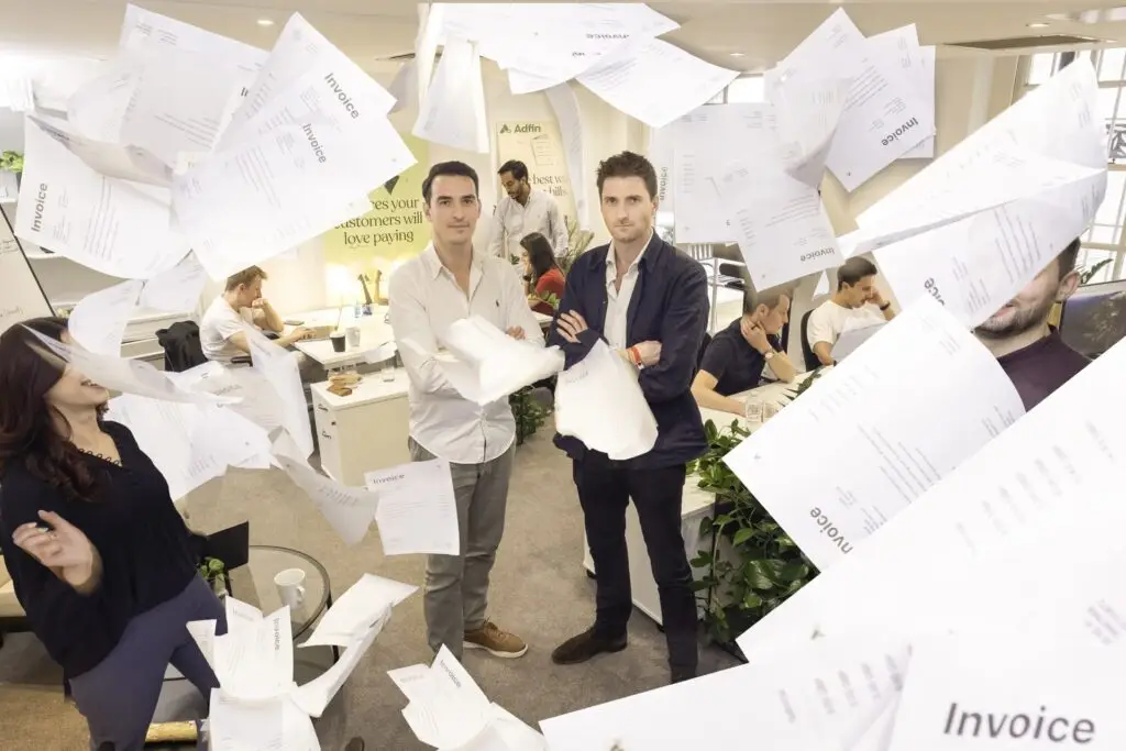 Office workers surrounded by flying paper invoices