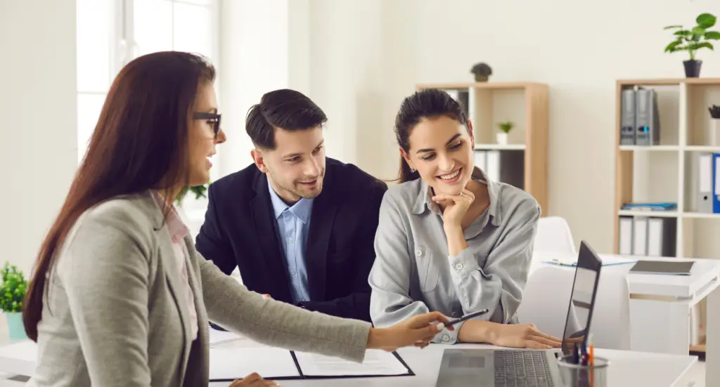 Accountant meeting two clients to go through documents at a desk