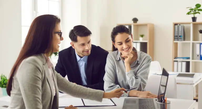 Accountant meeting two clients to go through documents at a desk